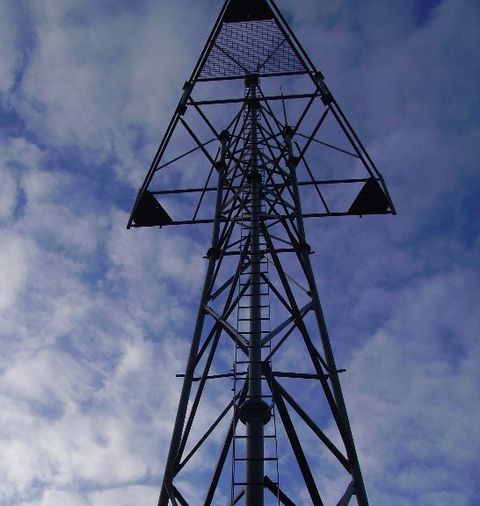 A tall pylon against a darkening sky